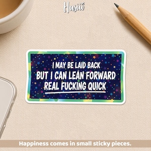 May include: A rectangular sticker with a white border and a dark blue background filled with colorful stars. The sticker reads "I MAY BE LAID BACK BUT I CAN LEAN FORWARD REAL FUCKING QUICK." The phrase "Happiness comes in small sticky pieces" is at the bottom.