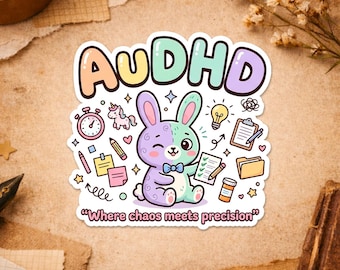 May include: A colorful sticker with the word "AUDHD" in pastel colors. A cartoon bunny winks, holding a notepad and pencil. The sticker includes the text "Where chaos meets precision" and "Happiness comes in small sticky pieces."