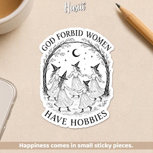 May include: A black and white sticker featuring a circle of women in witch hats, holding hands under a crescent moon and stars. The text reads "GOD FORBID WOMEN HAVE HOBBIES." The sticker is surrounded by a tree branch design.