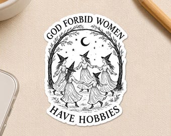 May include: A black and white sticker featuring a circle of women in witch hats, holding hands under a crescent moon and stars. The text reads "GOD FORBID WOMEN HAVE HOBBIES." The sticker is surrounded by a tree branch design.