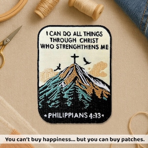 May include: Embroidered patch with the text "I CAN DO ALL THINGS THROUGH CHRIST WHO STRENGTHENS ME" and "PHILIPPIANS 4:13". The patch features a mountain scene with a cross, birds, and trees. The patch is rectangular with rounded corners.