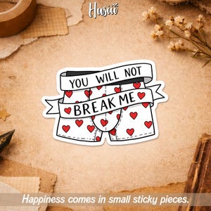 May include: A white sticker featuring cartoon boxer shorts with red hearts. A banner above the shorts reads "YOU WILL NOT BREAK ME." The phrase "Happiness comes in small sticky pieces" is at the bottom.