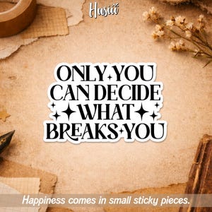 May include: A white sticker with the text "ONLY YOU CAN DECIDE WHAT BREAKS YOU" in a bold, black font. The sticker is surrounded by a neutral-toned background with the text "Happiness comes in small sticky pieces."