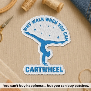 May include: Embroidered patch with a blue gymnast doing a cartwheel. The patch has the text "WHY WALK WHEN YOU CAN" and "CARTWHEEL" in blue. The patch is white with blue stitching. The background includes sewing supplies.