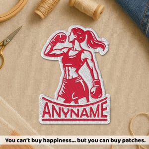 May include: Red and white embroidered patch featuring a female boxer in a fighting stance, wearing boxing gloves and athletic wear. The patch has the text "ANYNAME" at the bottom. The image also includes the text: "You can't buy happiness... but you can buy patches."
