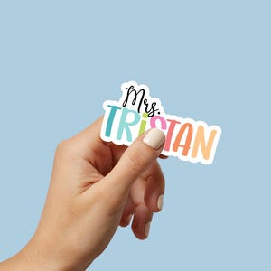 K&ouml;nnte beinhalten: Ein bunter Aufkleber mit dem Text "Mrs. Tristan" in einer Regenbogen-Schriftart.