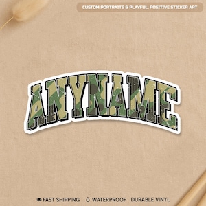 May include: A sticker with the word "ANYNAME" in a camouflage pattern, outlined in white, and set against a tan background. The text is in a bold, blocky font. The sticker also has the text "CUSTOM PORTRAITS & PLAYFUL, POSITIVE STICKER ART".