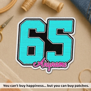 May include: A custom embroidered patch featuring the number "65" in turquoise with a black outline and a white border. The word "Anyname" is in a pink script font. The patch is on a beige background. The text at the bottom says "You can't buy happiness... but you can buy patches."