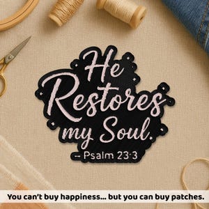 May include: Black embroidered patch with the text "He Restores my Soul. Psalm 23:3" in white script. The patch is surrounded by a decorative border. The image also includes sewing supplies and the text "You can't buy happiness... but you can buy patches."