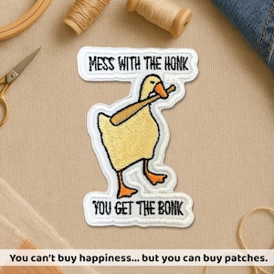 May include: Embroidered patch featuring a yellow duck with a baseball bat, with the text "MESS WITH THE HONK" and "YOU GET THE BONK". The patch is white with black and orange accents. The image also includes sewing supplies.