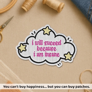May include: Embroidered patch in the shape of a cloud with the text "i will succeed because i am insane" in pink. The patch has a black border and yellow star accents. The patch is on a beige surface.