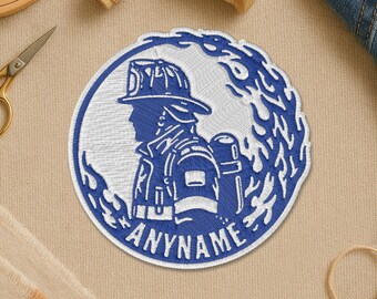 May include: Embroidered patch featuring a blue and white firefighter design within a circular frame. The patch includes the text "ANYNAME" and is surrounded by stylized flames. The image also includes the text: "You can't buy happiness... but you can buy patches."