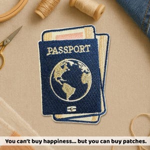 Peut inclure: Écusson brodé en forme de passeport bleu marine avec le mot "PASSPORT" et un globe doré. Le patch est superposé sur un fond beige. Des fournitures de couture sont visibles.