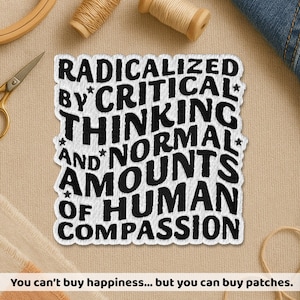 May include: A white embroidered patch with black text that reads "RADICALIZED BY CRITICAL THINKING AND NORMAL AMOUNTS OF HUMAN COMPASSION." The patch is surrounded by a white border. The text "You can't buy happiness... but you can buy patches" is at the bottom.
