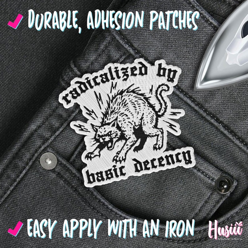 Peut inclure: &Eacute;cusson brod&eacute; avec une illustration en noir et blanc d'un chat en col&egrave;re, avec le texte "radicalized by basic decency". L'&eacute;cusson est sur un fond en jean gris. Le texte "Durable, Adhesion Patches" et "Easy Apply With An Iron" sont &eacute;galement visibles.