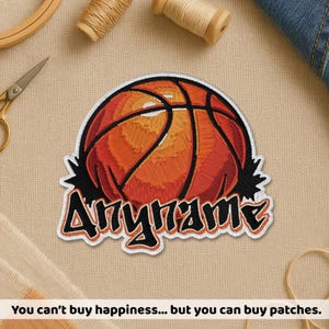 May include: Embroidered patch featuring a basketball design in shades of orange and red, with black accents. The patch includes the word "Anyname" in a stylized font. The patch is bordered with white stitching.