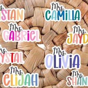 May include: Nine colorful teacher name tags with the title "Mrs." followed by a name. The names are Tristan, Camilla, Gabriel, Jayden, Crystal, Olivia, Elijah, and Shannon.