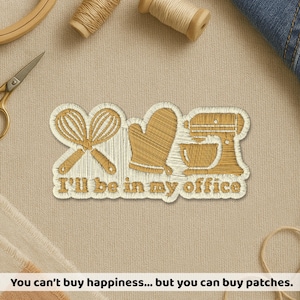 May include: An embroidered patch featuring gold-colored thread designs of two crossed whisks, an oven mitt, and a stand mixer. Below the icons, the text "I'll be in my office" is stitched in gold thread against a white background.