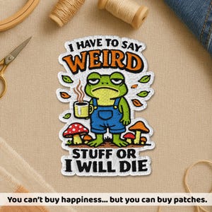 May include: Embroidered patch featuring a grumpy frog wearing blue overalls, holding a coffee cup, and surrounded by mushrooms and leaves. Text reads "I HAVE TO SAY WEIRD STUFF OR I WILL DIE."