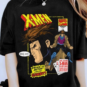 May include: Black t-shirt with a comic book cover design featuring Gambit from X-Men. The cover features Gambit in a purple and brown costume, holding playing cards. The text on the cover reads "Enter the Mutant Called Gambit!" and "The Cajun X-Man in His Own Limited Series!"