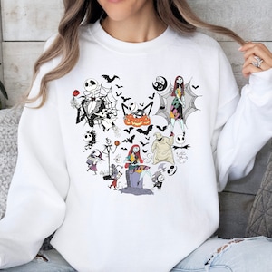 May include: White sweatshirt with a graphic print of characters from the Nightmare Before Christmas movie. The characters are arranged in a heart shape and include Jack Skellington, Sally, and Oogie Boogie.