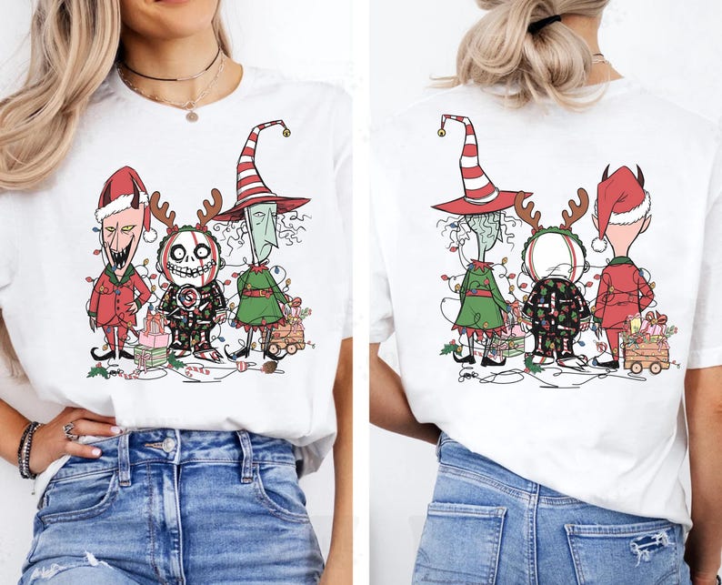 K&ouml;nnte beinhalten: Wei&szlig;es T-Shirt mit einer Cartoon-Illustration von drei Figuren in Weihnachtsoutfits. Die Figuren tragen einen roten Weihnachtsmannhut, einen Hexenhut und ein Rentier-Geweih-Stirnband. Das Design umfasst Lichterketten und Geschenkboxen.