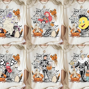 May include: Cream-colored t-shirts featuring Halloween-themed designs. Each shirt showcases a different character from The Little Mermaid, including Ursula, Ariel, Flounder, Sebastian, Prince Eric, and King Triton, all in skeleton form, with pumpkins and spiderwebs.
