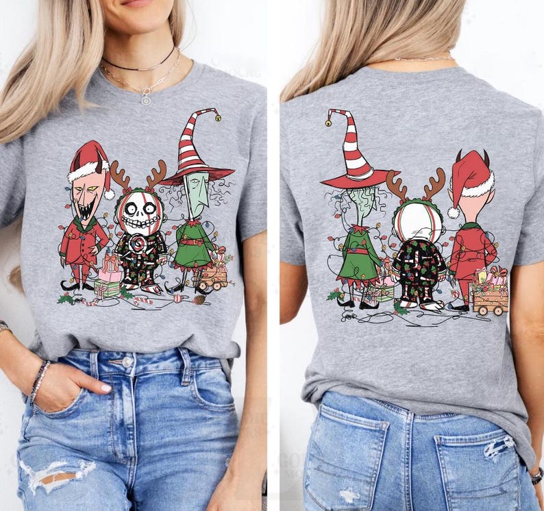 K&ouml;nnte beinhalten: Hellgraues T-Shirt mit einer Grafik von drei Cartoon-Charakteren in Weihnachtsoutfits. Vorder- und R&uuml;ckseite des Shirts sind abgebildet. Die Charaktere sind mit Weihnachtsbeleuchtung geschm&uuml;ckt und stehen vor verpackten Geschenken.