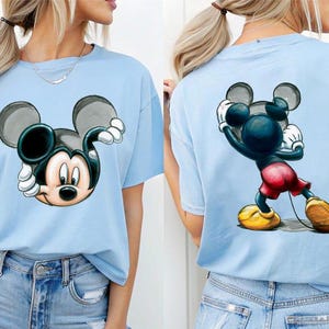 May include: A set of three ceramic mugs with a speckled, cream-colored glaze. Each mug features a different hand-painted floral design in shades of blue, green, and yellow. The mugs have a simple, rounded shape and a comfortable handle.