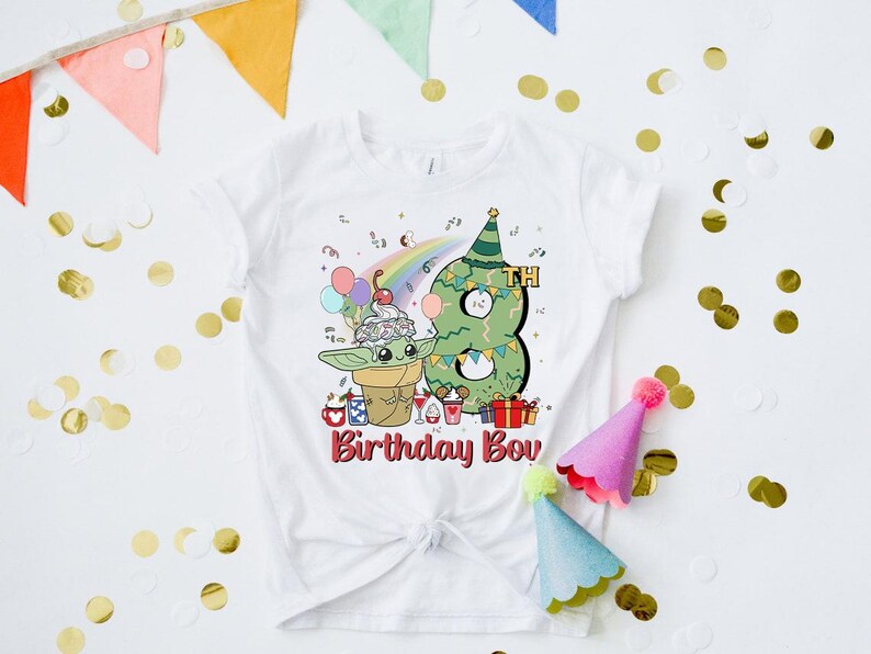 May include: White t-shirt with a green alien character holding a cup of ice cream and a green Christmas tree shaped like the number 8. The text "8th Birthday Boy" is printed on the shirt.