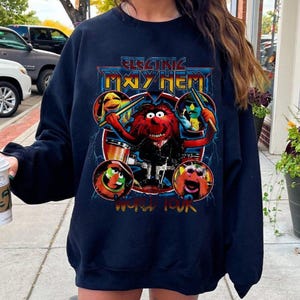 May include: Black sweatshirt with a graphic print of a red Muppet character playing drums. The text "Electric Mayhem World Tour" is printed below the image.