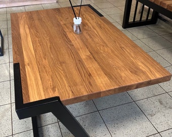 May include: A wooden coffee table with a black metal frame. The table has a rectangular top and a geometric base.