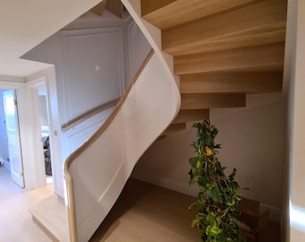 May include: A white curved staircase with wooden steps leading up to a landing. The staircase is in a modern home with white walls and light wood floors. A potted plant is in the corner of the room.