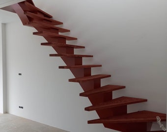 May include: A modern, red wooden staircase with a unique, angled design. The staircase is attached to a white wall and leads up to a higher level.