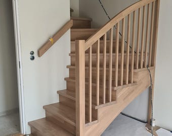May include: A wooden staircase with a curved railing and a white wall in the background.