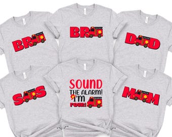 Puede incluir: Seis camisetas grises con texto rojo y un gráfico de camión de bomberos. Las camisetas muestran las palabras "BR", "DAD", "MOM", "BRD", "SOUND THE ALARM! I'M FOUR!" y "SAS".