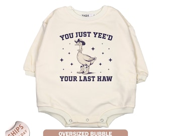 May include: Cream-colored, long-sleeve bodysuit with a graphic of a goose wearing a cowboy hat and boots. Text reads "YOU JUST YEE'D YOUR LAST HAW". The bodysuit is an oversized bubble style.