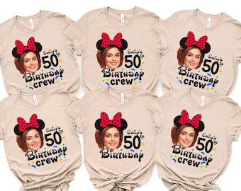 May include: Beige t-shirts with a graphic featuring a woman wearing a Minnie Mouse headband. The text reads "Emily's 50th Birthday Crew" in black and green, with colorful star accents. A fun, personalized birthday theme.
