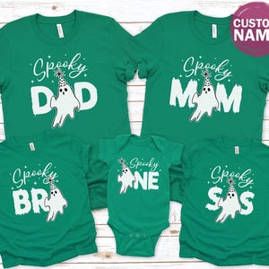 a collection of green t-shirts with the word "Spooky" printed on them, along with various ghost-related designs.