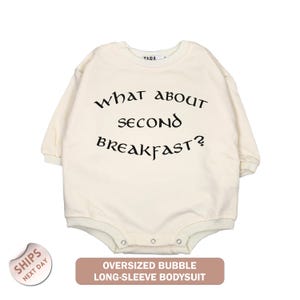 a white long-sleeved bodysuit with the text "What about second breakfast?" printed on it.