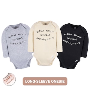 Three long-sleeve onesies with the same text printed on them, arranged in a row.