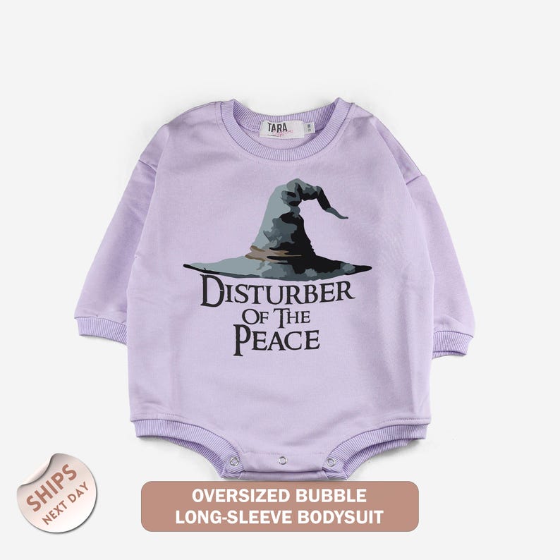 A long-sleeved purple bodysuit with a graphic of a wizard's hat and the text "Disturb of the Peace" printed on it.