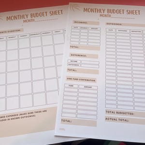 Könnte beinhalten: Zwei weiße monatliche Budgetblätter mit beigefarbener Schrift. Die Blätter haben Abschnitte für Einnahmen, Ausgaben und einen Wochenüberblick. Der Text enthält "Monthly Budget Sheet" und "Month".