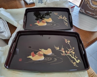 Dos bandejas de madera lacada de estilo japonés, una de 48 x 42 cm y la otra de 42 x 27 cm.