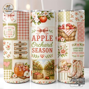 May include: Three cylindrical tumblers featuring a patchwork design with apple orchard themes. Graphics include red apples, a wooden basket, a jar of cider, cowboy boots, a hat, and text reading Apple Orchard Season, Sweeter Than Apple Cider.