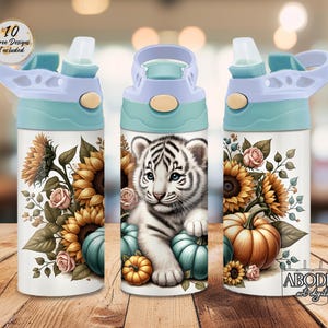 May include: A white water bottle with a light blue lid and a design featuring a white tiger cub, sunflowers, pumpkins, and roses. The bottle has a push-button opening and a straw. The text "10 Free Designs Included" is visible.