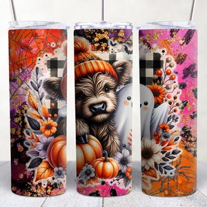 May include: Three stainless steel tumblers with a fall and Halloween theme. The tumblers feature a Highland cow wearing a knitted hat, pumpkins, flowers, and a ghost. The background is a mix of black and white checkered, orange, pink, and purple.