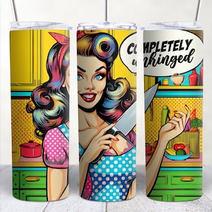 May include: A stainless steel tumbler with a pop art design featuring a woman holding a knife in a kitchen setting. The text "COMPLETELY unhinged" is in a speech bubble above her head.