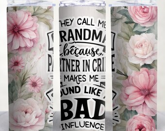 May include: A stainless steel tumbler with a floral design and the text "They call me grandma because partner in crime makes me sound like a bad influence".
