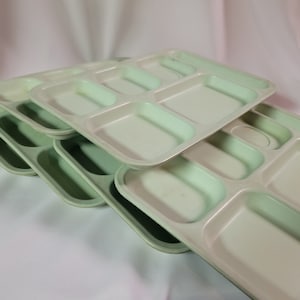 May include: Stack of four light green plastic divided trays. Each tray has six compartments.